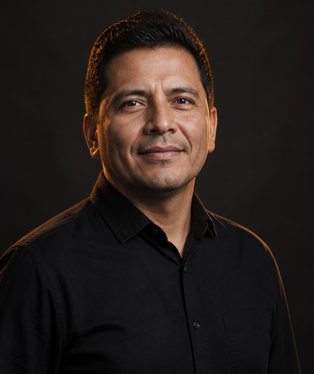 Portrait of evangelist Hiubert Zamora against a dark background with warm light